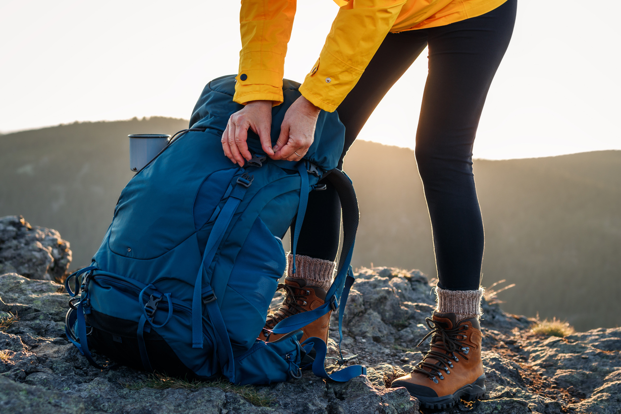 woman opening her backpack after climbing mountain