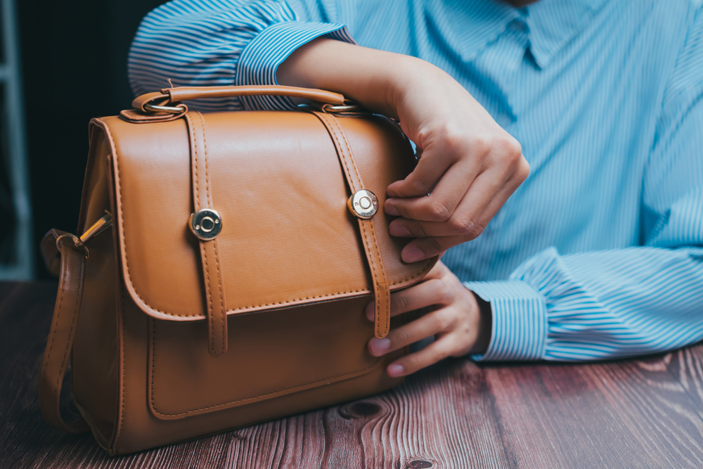 A woman with a stylish leather handbag